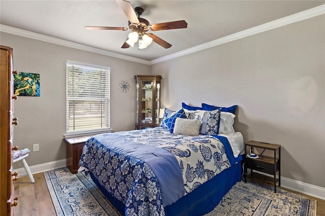 bedroom featuring baseboards, ornamental molding, ceiling fan, and wood finished floors