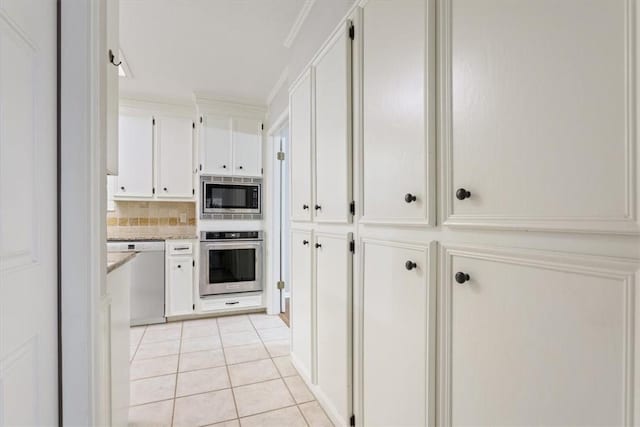 kitchen with light tile patterned floors, appliances with stainless steel finishes, crown molding, and white cabinetry