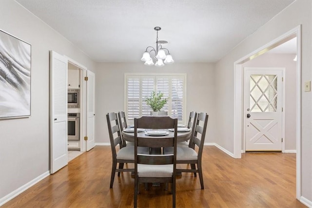 dining area featuring an inviting chandelier and light hardwood / wood-style floors