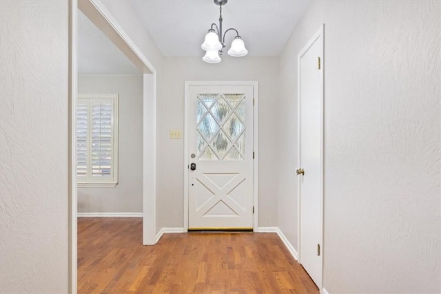 foyer with hardwood / wood-style flooring and a chandelier