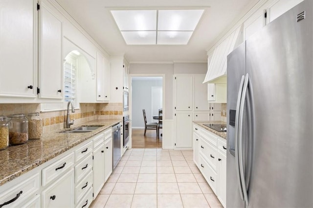 kitchen featuring stainless steel appliances, white cabinetry, sink, and light stone countertops