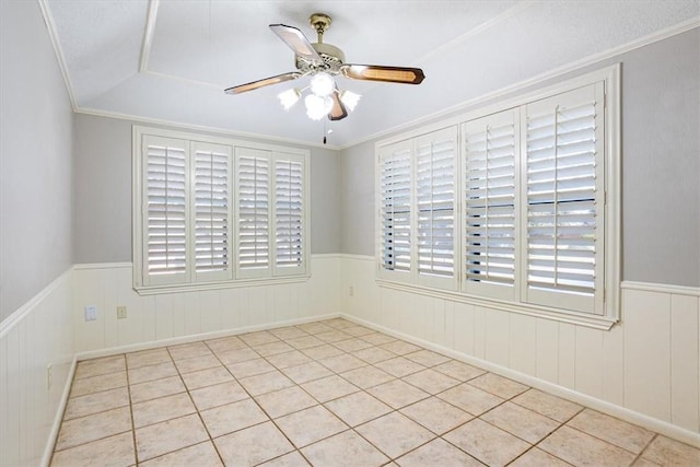 tiled empty room featuring ceiling fan and ornamental molding