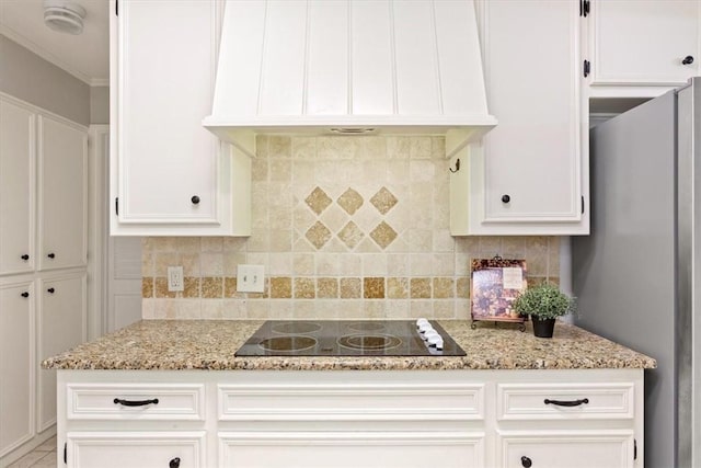 kitchen featuring white cabinets, black electric stovetop, light stone countertops, and premium range hood