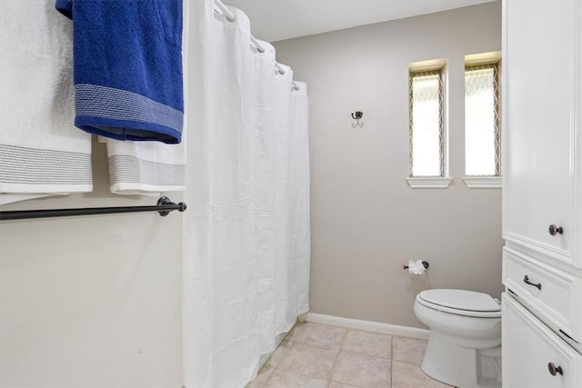 bathroom with toilet and tile patterned flooring