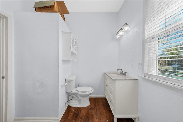 bathroom featuring wood-type flooring, vanity, and toilet