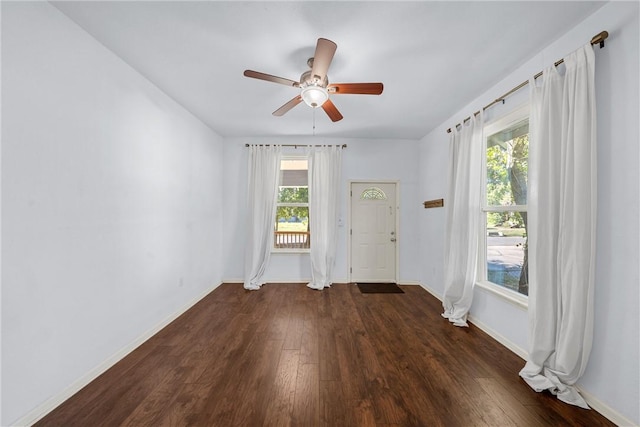 empty room featuring ceiling fan, dark hardwood / wood-style flooring, and a wealth of natural light