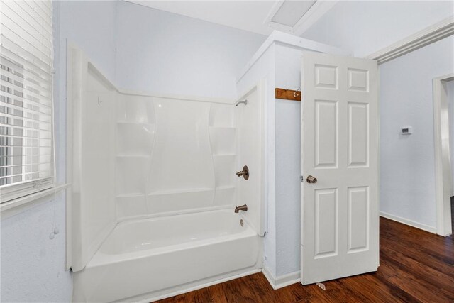 bathroom featuring wood-type flooring and bathing tub / shower combination