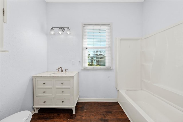 full bathroom with hardwood / wood-style floors, vanity, toilet, and  shower combination