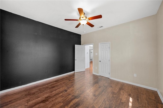 empty room with ceiling fan and dark hardwood / wood-style flooring