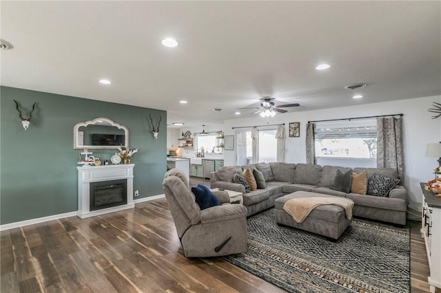 living room with dark hardwood / wood-style floors, ceiling fan, and sink