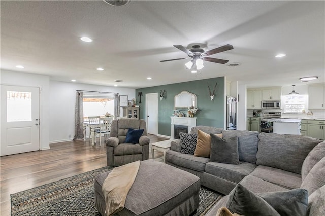 living room featuring ceiling fan and hardwood / wood-style floors