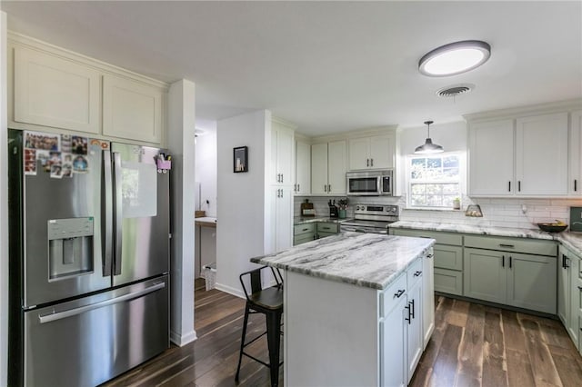 kitchen featuring stainless steel appliances, tasteful backsplash, dark hardwood / wood-style flooring, decorative light fixtures, and a kitchen island