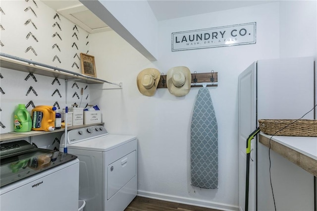 clothes washing area featuring dark hardwood / wood-style flooring and washing machine and dryer