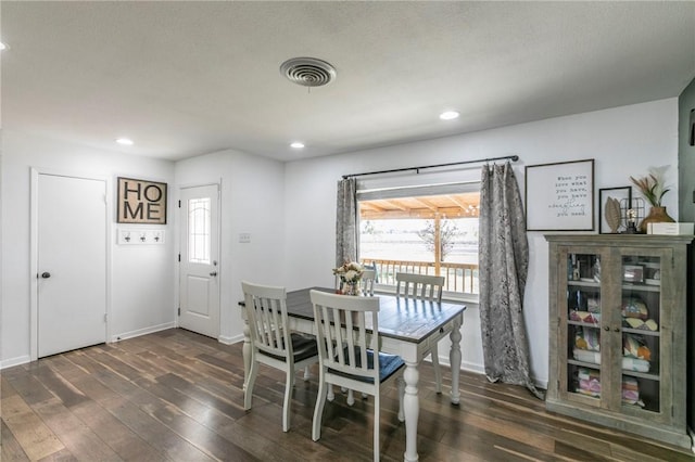 dining room with dark wood-type flooring and a textured ceiling