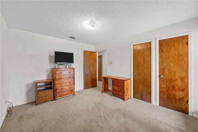 carpeted bedroom featuring a textured ceiling