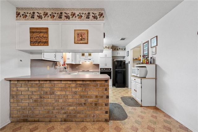 kitchen featuring kitchen peninsula, a textured ceiling, white cabinetry, and black appliances