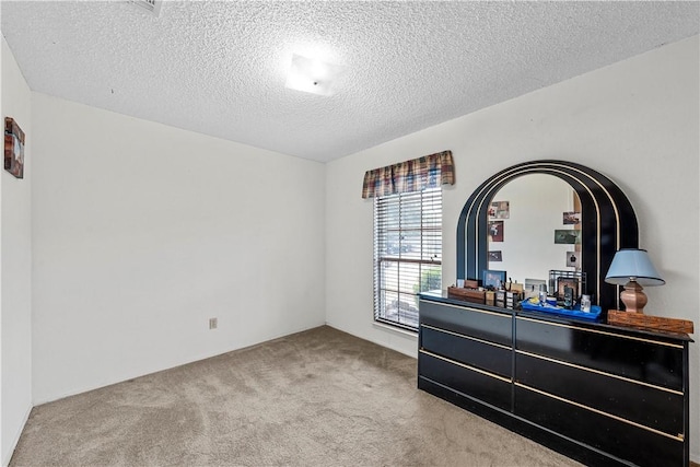 bedroom featuring carpet and a textured ceiling