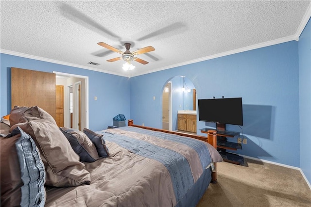 bedroom with connected bathroom, ceiling fan, carpet floors, a textured ceiling, and ornamental molding