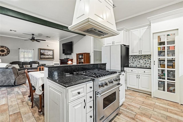 kitchen with fridge, ornamental molding, white cabinetry, and stainless steel stove