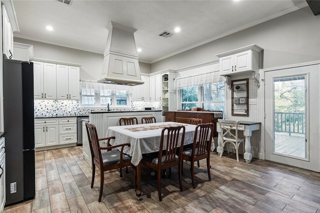 dining space featuring plenty of natural light, crown molding, and hardwood / wood-style floors