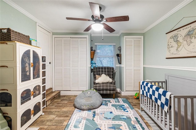 bedroom featuring ceiling fan, multiple closets, a nursery area, and ornamental molding