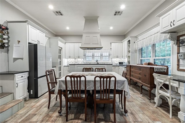 dining space with plenty of natural light and ornamental molding