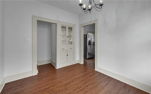 unfurnished dining area featuring dark hardwood / wood-style floors and a chandelier