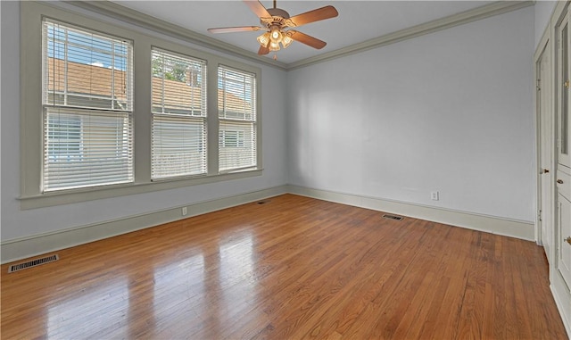 spare room featuring hardwood / wood-style floors, ceiling fan, and crown molding