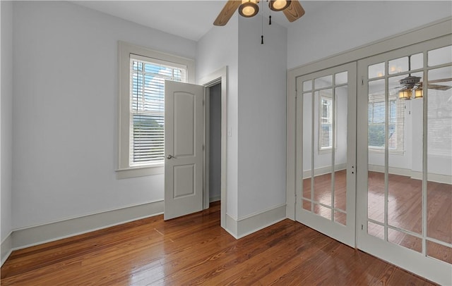 unfurnished room with hardwood / wood-style flooring, ceiling fan, and french doors