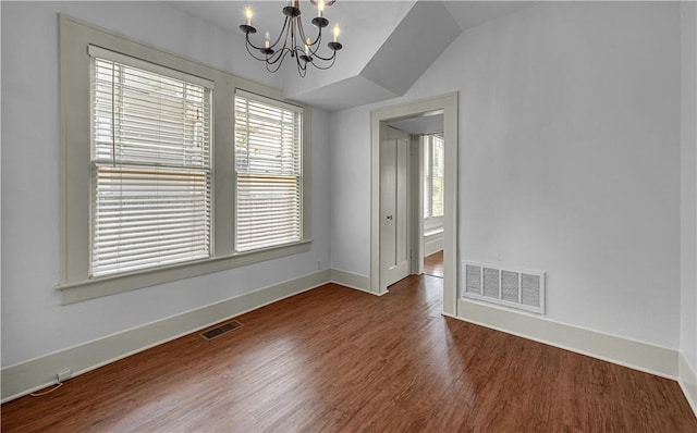 empty room with dark hardwood / wood-style floors, an inviting chandelier, and lofted ceiling