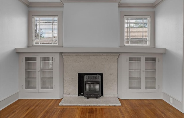 interior details with hardwood / wood-style flooring, a wood stove, and ornamental molding