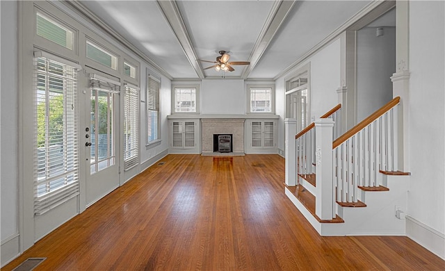 unfurnished living room featuring ceiling fan, wood-type flooring, and ornamental molding