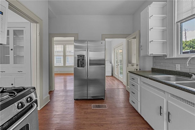 kitchen with backsplash, sink, dark hardwood / wood-style floors, appliances with stainless steel finishes, and white cabinetry