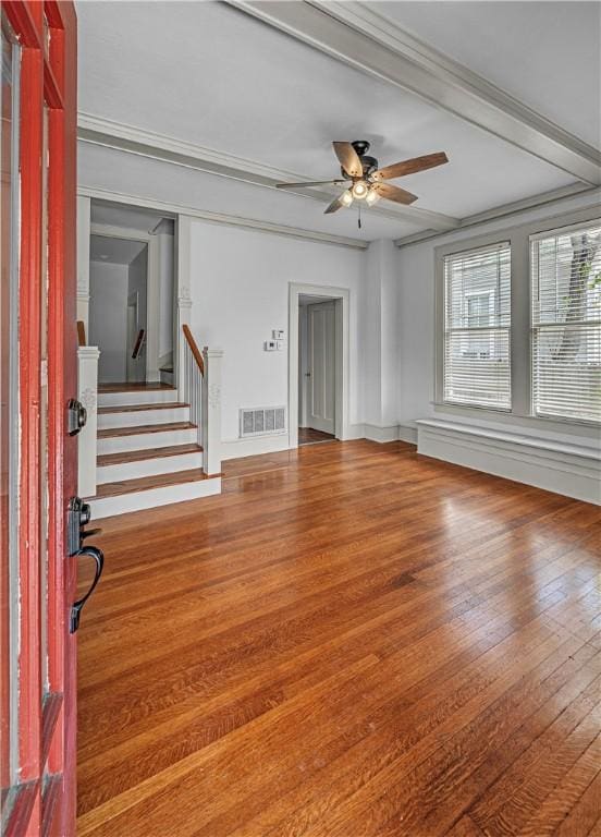 interior space with ceiling fan, beam ceiling, wood-type flooring, and crown molding