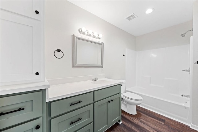 full bathroom with hardwood / wood-style floors, vanity, toilet, and shower / washtub combination