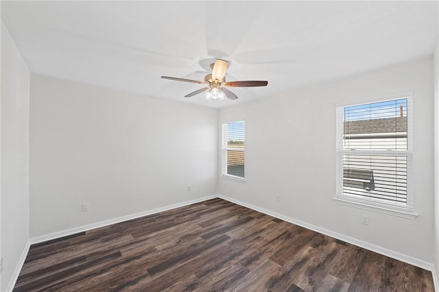 unfurnished room featuring ceiling fan, a healthy amount of sunlight, and dark wood-type flooring