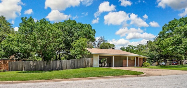 exterior space with a carport and a lawn