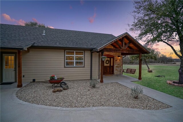 view of front of house with a patio and a lawn