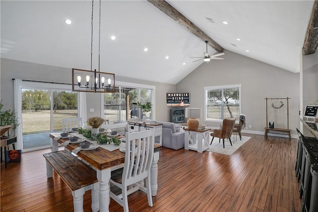 dining area with ceiling fan with notable chandelier, beam ceiling, dark hardwood / wood-style flooring, and high vaulted ceiling