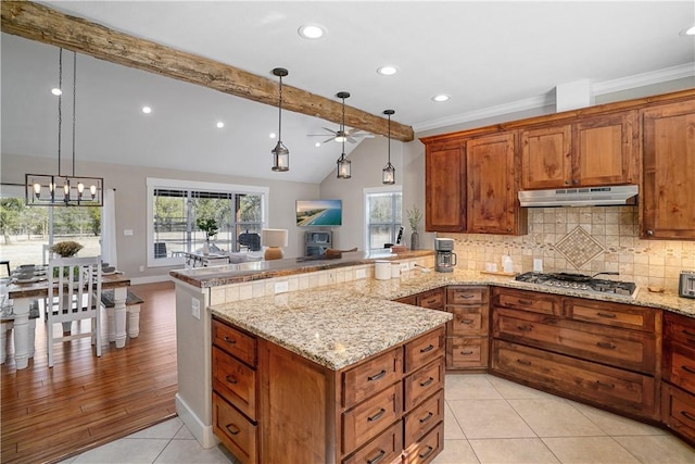 kitchen with pendant lighting, lofted ceiling with beams, decorative backsplash, light hardwood / wood-style floors, and stainless steel gas cooktop