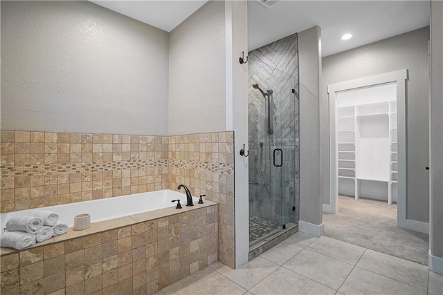 bathroom featuring tile patterned floors and shower with separate bathtub