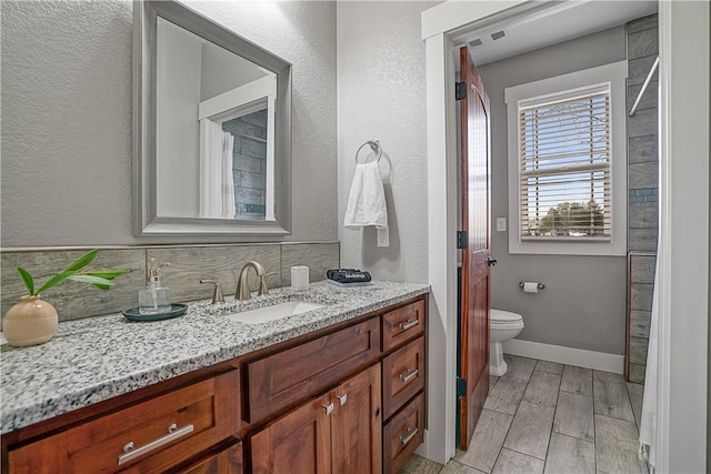 bathroom featuring vanity, wood-type flooring, and toilet