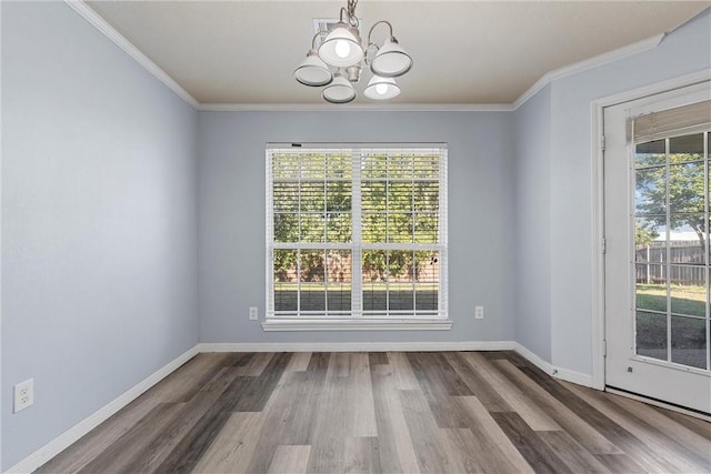 unfurnished dining area featuring crown molding, hardwood / wood-style floors, and a chandelier