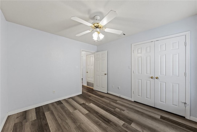 unfurnished bedroom with a closet, ceiling fan, and dark hardwood / wood-style flooring