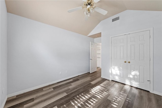 unfurnished bedroom with ceiling fan, vaulted ceiling, dark hardwood / wood-style floors, and a closet