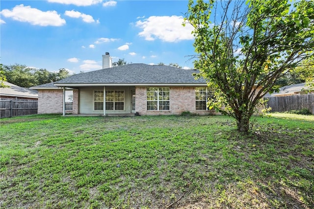 rear view of house featuring a lawn