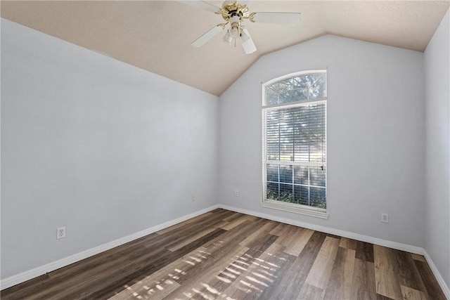 empty room featuring a textured ceiling, dark hardwood / wood-style floors, ceiling fan, and lofted ceiling