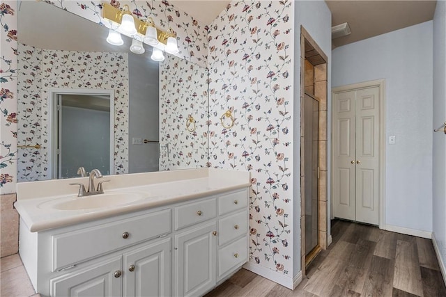 bathroom featuring walk in shower, vanity, and hardwood / wood-style flooring