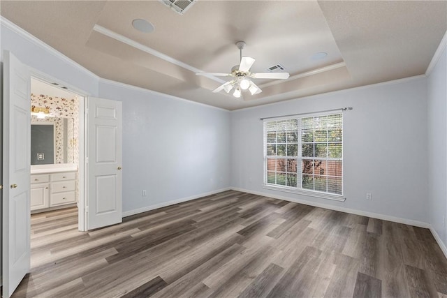 unfurnished bedroom featuring hardwood / wood-style floors, ceiling fan, and a raised ceiling