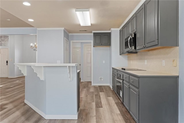 kitchen with gray cabinets, light hardwood / wood-style floors, and appliances with stainless steel finishes